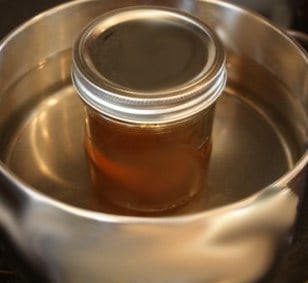 Honey in a pot of hot water. Crystallized honey can be liquefied.