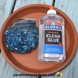 Clay dish, pebbles and glue to make a bee waterer image.