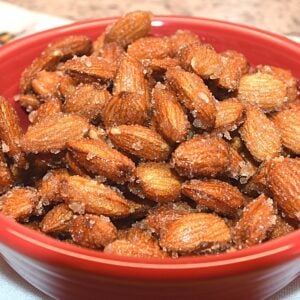 Fresh honey roasted almonds in a red bowl image.