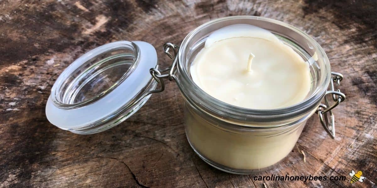 DIY Beeswax candle in jar on a large tree stump image.