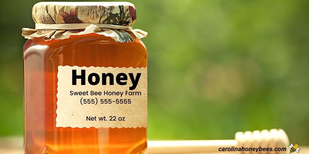 Jar of amber colored honey with a paper covered cap and a honey label for selling image.