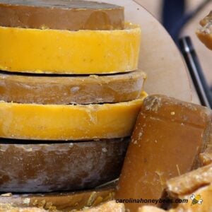 Various colors of beeswax cakes stacked in a shed image.