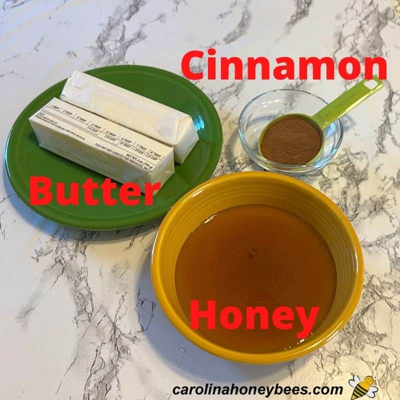 Honey, butter and cinnamon in dishes on table.