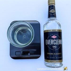 Kitchen scale with glass and bottle of everclear.
