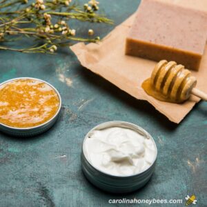 Beeswax, honey with dipper and homemade skin care products.