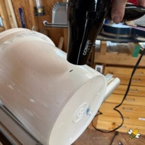 Heat surface of plastic bucket with heat gun.
